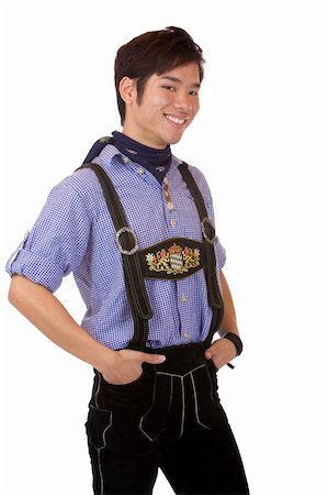 Closeup of young man dressed in Bavarian Oktoberfest leather trousers, which smiles happy into camera. Isolated on white. Fotografie stock - Microstock e Abbonamento, Codice: 400-04680526