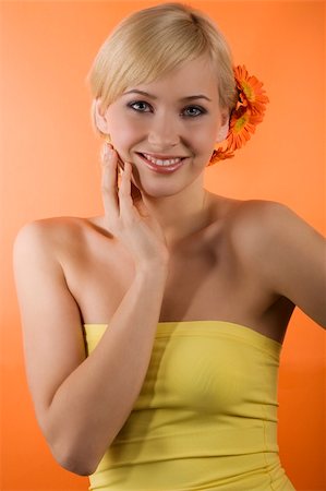 simsearch:400-08116534,k - young beauty blond girl with yellow top and hair style with gerbera and orange background Stock Photo - Budget Royalty-Free & Subscription, Code: 400-04681149