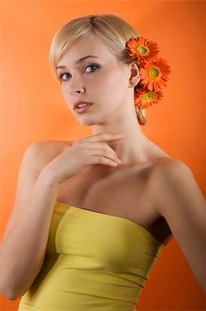 simsearch:400-04863868,k - young beauty blond girl with yellow top and hair style made with gerbera on orange background looking in camera Stock Photo - Budget Royalty-Free & Subscription, Code: 400-04681150