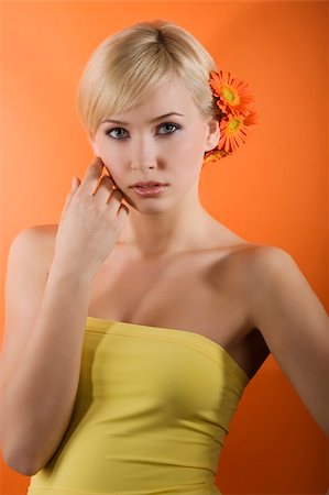 simsearch:400-04863868,k - young beauty blond girl with yellow top and hair style made with gerbera on orange background Stock Photo - Budget Royalty-Free & Subscription, Code: 400-04681151