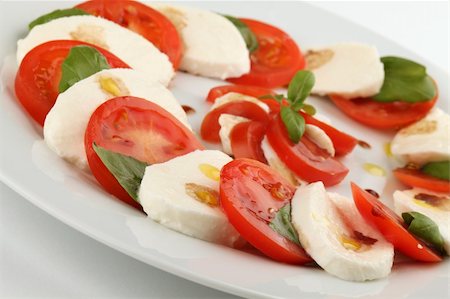 Slices of tomatoes and mozzarella with basil leaves, olive oil and balsamic vinegar Photographie de stock - Aubaine LD & Abonnement, Code: 400-04683866