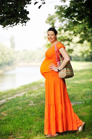 simsearch:400-05230300,k - beautiful young happy pregnant woman outdoor in bright nature in orange dress Stock Photo - Budget Royalty-Free & Subscription, Code: 400-04694732