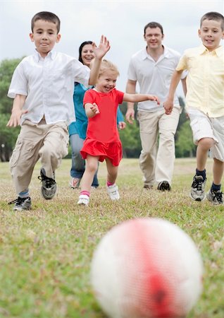 soccer boy length - Beautiful family of five on outdoors running towards the foot ball and playing on the park Stock Photo - Budget Royalty-Free & Subscription, Code: 400-04694960