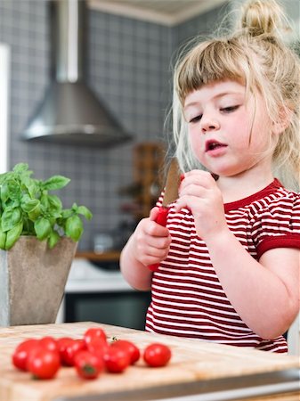 Young girl cutting tomatoes in the kitchen Stock Photo - Budget Royalty-Free & Subscription, Code: 400-04695047