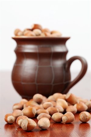 simsearch:400-06520688,k - Hazelnuts on wooden table and in a ceramic mug Stock Photo - Budget Royalty-Free & Subscription, Code: 400-04695310