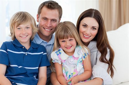 Portrait of family in living-room sitting on sofa together at home Stock Photo - Budget Royalty-Free & Subscription, Code: 400-04696616