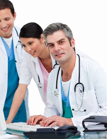 Cheerful medical team working at a computer against a white background Stock Photo - Budget Royalty-Free & Subscription, Code: 400-04696636