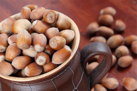 simsearch:400-06520688,k - Hazelnuts in a ceramic mug and on wooden table Stock Photo - Budget Royalty-Free & Subscription, Code: 400-04697123