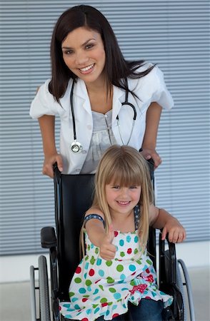 slogatura - Young female doctor and Smiling girl on a wheelchair with thumb up in the hospital Fotografie stock - Microstock e Abbonamento, Codice: 400-04697264