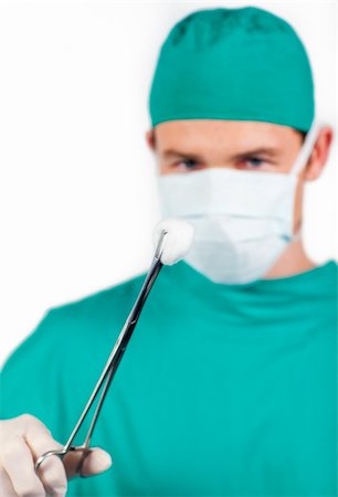 simsearch:400-07793824,k - Charismatic male surgeon holding surgical forceps against a white background Foto de stock - Royalty-Free Super Valor e Assinatura, Número: 400-04697302