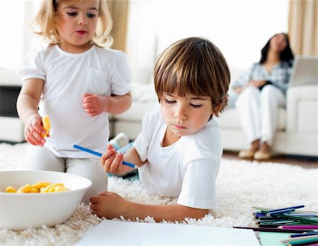 simsearch:6109-07601494,k - Adorable children eating chips and drawing lying on the floor Stock Photo - Budget Royalty-Free & Subscription, Code: 400-04697397