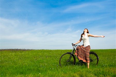 simsearch:400-04201795,k - Happy young woman with a vintage bicycle on a green meadow Fotografie stock - Microstock e Abbonamento, Codice: 400-04697435