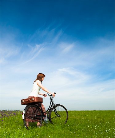 simsearch:400-04201795,k - Happy young woman on a green meadow with a vintage bicycle Fotografie stock - Microstock e Abbonamento, Codice: 400-04697437