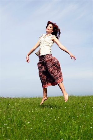 Young woman jumping on a beautiful green meadow Stock Photo - Budget Royalty-Free & Subscription, Code: 400-04697444