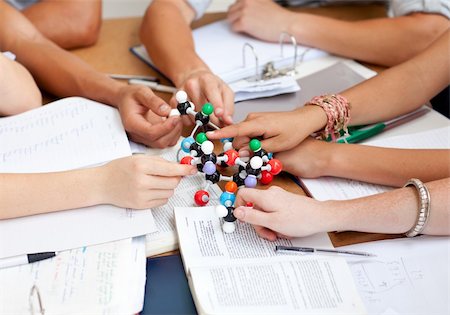 simsearch:400-04841324,k - Close-up of teenagers studying and holding molecules in a library Photographie de stock - Aubaine LD & Abonnement, Code: 400-04697627