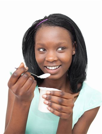 Happy young woman eating a yogurt against a white background Stock Photo - Budget Royalty-Free & Subscription, Code: 400-04699112