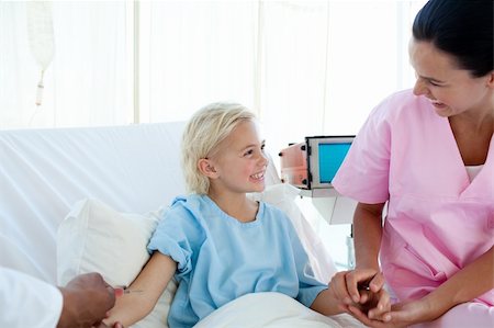 Young nurse smiling to a little girl who receiving an injection in a hospital Stock Photo - Budget Royalty-Free & Subscription, Code: 400-04699438