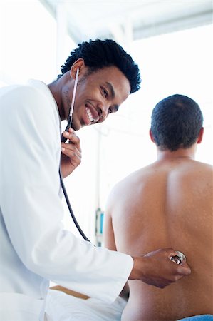 simsearch:400-04907865,k - Afro-american doctor attending a male patient in a hospital Photographie de stock - Aubaine LD & Abonnement, Code: 400-04699464