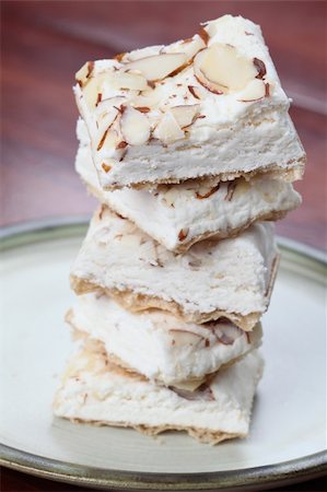 A confectionary similar to the hard variety of the Spanish turron and Italian torrone produced in the Czech Republic. It is called "Turecky med" - literally "Turkish honey" and it is made from egg white, honey and various kinds of nuts. Fotografie stock - Microstock e Abbonamento, Codice: 400-04699511