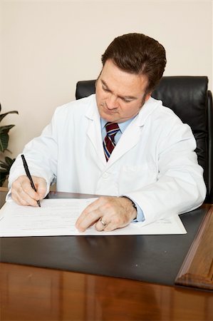 doctors reviewing medical records - Doctor at his desk writing in a patient's chart. Stock Photo - Budget Royalty-Free & Subscription, Code: 400-04699556