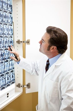 doctor with ct scan - Chiropractic doctor examining a CT scan of the spine. Stock Photo - Budget Royalty-Free & Subscription, Code: 400-04699553