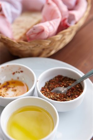 White plate with condiments as served with a traditional turkish meal, including olive oil, paprika and an empty bowl of sundered tomatoes with some homemade flat bread Stock Photo - Budget Royalty-Free & Subscription, Code: 400-04690101