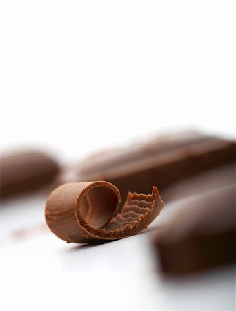 Close-up facture of a curl of chocolate on white with a piece of chocolate at the background Stock Photo - Budget Royalty-Free & Subscription, Code: 400-04690273