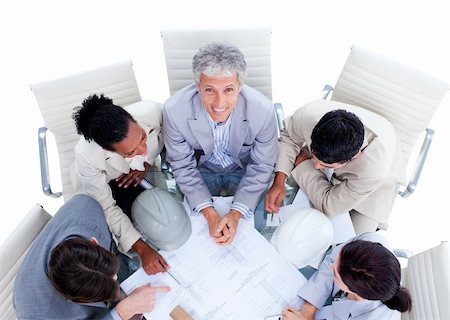 Positive multi-ethnic architects studying blueprints in a meeting Stock Photo - Budget Royalty-Free & Subscription, Code: 400-04690831
