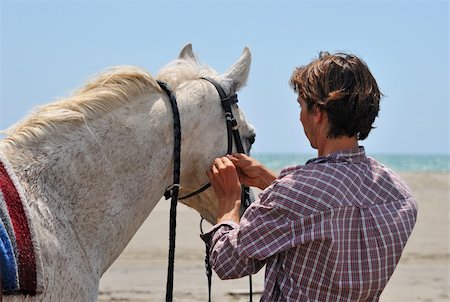 simsearch:400-04660370,k - man making a bridle to his horse on a beach Photographie de stock - Aubaine LD & Abonnement, Code: 400-04690947