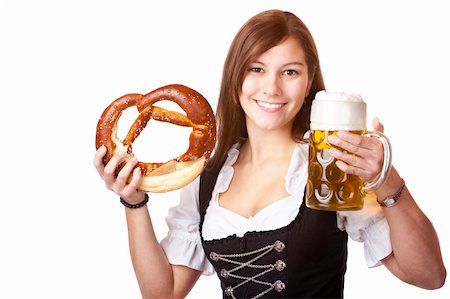 simsearch:400-04680527,k - Happy woman in dirndl dloth holding Oktoberfest beer stein and pretzel in hands. Isolated on white. Stockbilder - Microstock & Abonnement, Bildnummer: 400-04691911