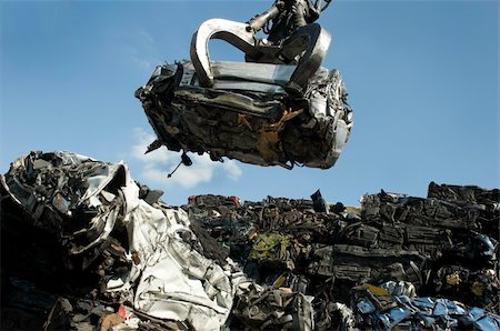 scrap yard pile of cars - A crushed car being lifted on to pile of other crushed cars in scrap yard Stock Photo - Budget Royalty-Free & Subscription, Code: 400-04692566