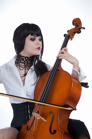 Attractive girl playing cello, studio shot over white background Stockbilder - Microstock & Abonnement, Bildnummer: 400-04692692