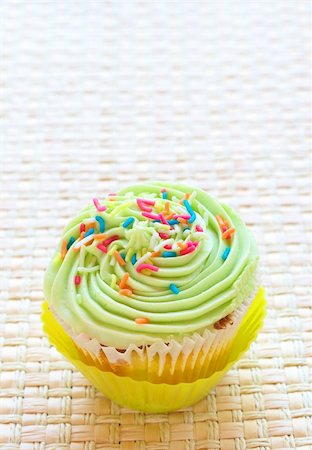 simsearch:400-05316582,k - Single Fresh vanilla cupcake lime icing and sprinkles on woven straw background Stock Photo - Budget Royalty-Free & Subscription, Code: 400-04693958