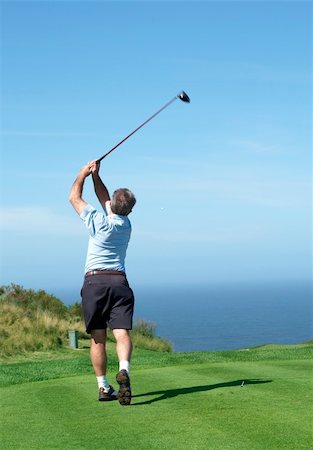 simsearch:400-04942072,k - Senior male golfer playing golf from the tee box on a beautiful summer day next to the ocean Foto de stock - Royalty-Free Super Valor e Assinatura, Número: 400-04693959