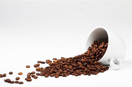 some coffee beans falling from a coffee cup on white background Stock Photo - Budget Royalty-Free & Subscription, Code: 400-04704348