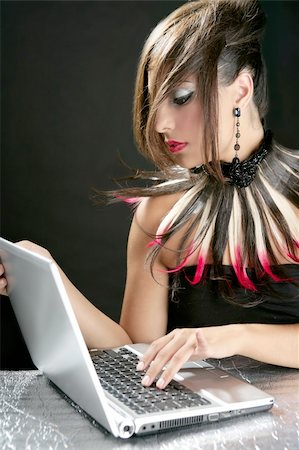 Attractive brunette fashion woman with laptop over black Photographie de stock - Aubaine LD & Abonnement, Code: 400-04704786