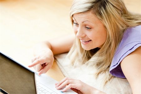 simsearch:400-04709946,k - Happy blond woman using a laptop lying on the floor at home Stockbilder - Microstock & Abonnement, Bildnummer: 400-04704991