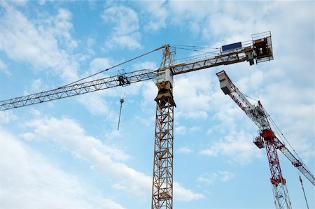 Cranes of a construction site against blue, cloudy sky Stock Photo - Budget Royalty-Free & Subscription, Code: 400-04706193