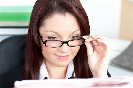 simsearch:632-01157433,k - Delighted businesswoman reading a newspaper wearing glasses sitting in her office Stock Photo - Budget Royalty-Free & Subscription, Code: 400-04706852