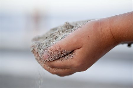 Close-up of a child's hands holding sand against moody blurry beach background Photographie de stock - Aubaine LD & Abonnement, Code: 400-04707605