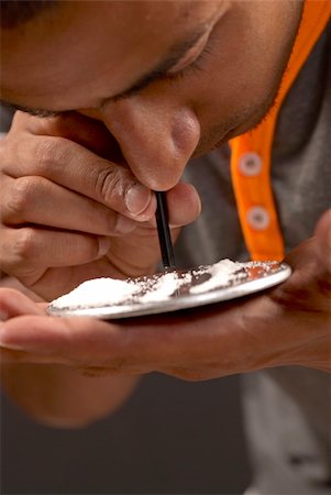 drogato - Young middle eastern man sniffing a line of cocaine Fotografie stock - Microstock e Abbonamento, Codice: 400-04707631