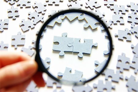 puzzle pieces hand - Hand with magnifying glass and puzzle isolated on white background Stock Photo - Budget Royalty-Free & Subscription, Code: 400-04707722
