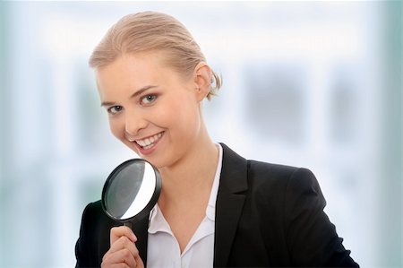 simsearch:400-04554899,k - Young attractive smiling business woman looking into a magnifying glass, isolated on white background Stock Photo - Budget Royalty-Free & Subscription, Code: 400-04708179