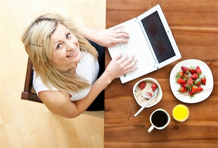 simsearch:400-04708507,k - Close-up of a woman using a laptop drinking coffee eating muesli Stock Photo - Budget Royalty-Free & Subscription, Code: 400-04708507