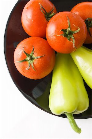 simsearch:400-04393618,k - Tomatoes and peppers washed and placed in a black ceramic plate isolated on white background top view Foto de stock - Royalty-Free Super Valor e Assinatura, Número: 400-04709536