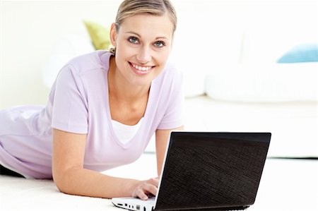 simsearch:400-04709946,k - Positive woman using her laptop on the floor in the living room Stockbilder - Microstock & Abonnement, Bildnummer: 400-04709945