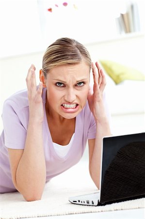 simsearch:400-04709946,k - Aggressive young woman using her laptop in the living room Stockbilder - Microstock & Abonnement, Bildnummer: 400-04709947