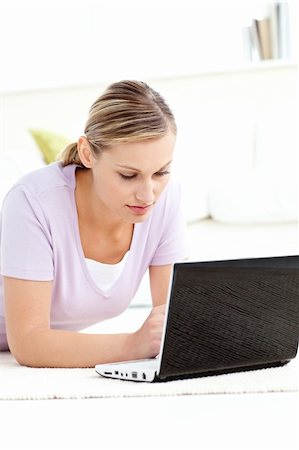 simsearch:400-04709946,k - Concentrated woman using her computer lying on the floor in the living room Stockbilder - Microstock & Abonnement, Bildnummer: 400-04709968