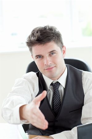 simsearch:400-04796133,k - Assertive businessman  holding out his hand in the office Stock Photo - Budget Royalty-Free & Subscription, Code: 400-04700124