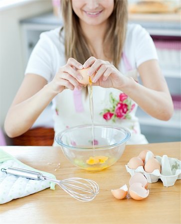 simsearch:400-04139196,k - Smiling young woman cooking Foto de stock - Royalty-Free Super Valor e Assinatura, Número: 400-04700295